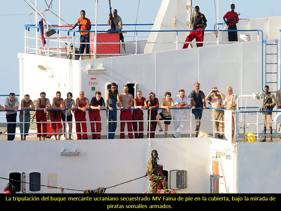 La tripulación del buque mercante ucraniano secuestrado MV Faina de pie en la cubierta, bajo la mirada de piratas somalíes armados.