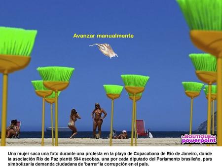 Una mujer saca una foto durante una protesta en la playa de Copacabana de Río de Janeiro, donde la asociación Río de Paz plantó 594 escobas, una por cada.