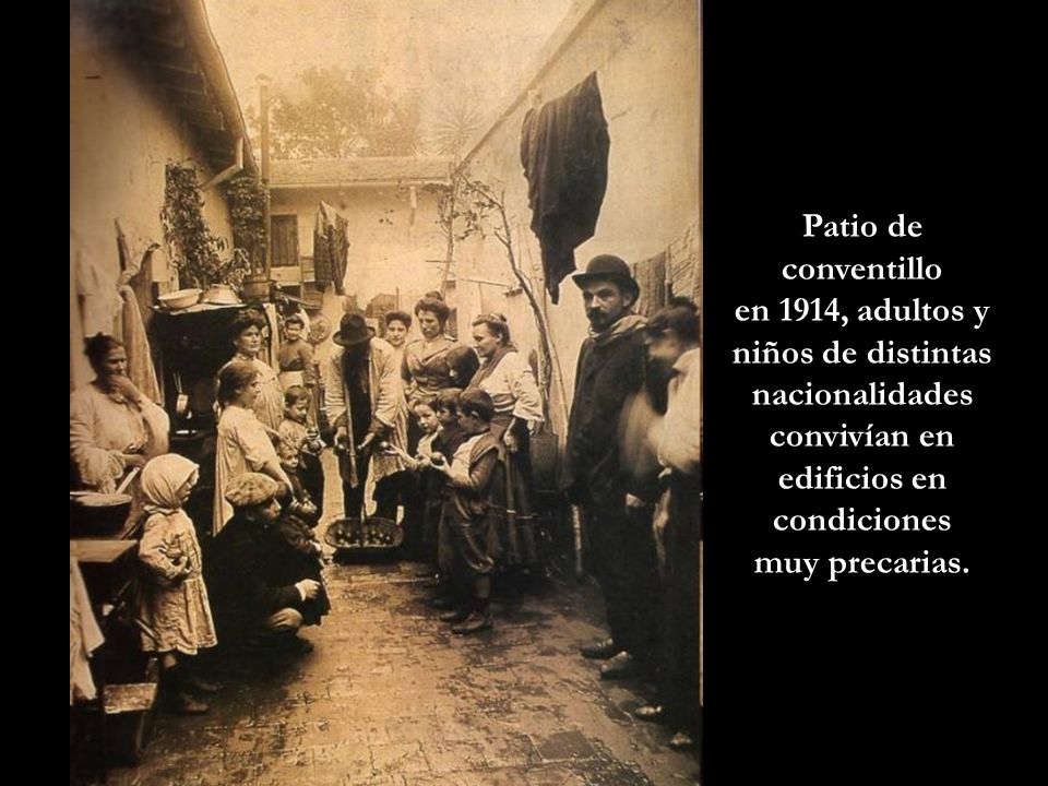 Patio de conventillo en 1914, adultos y niños de distintas nacionalidades convivían en edificios en condiciones.