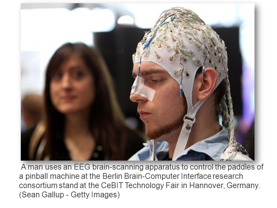 A man uses an EEG brain-scanning apparatus to control the paddles of a pinball machine at the Berlin Brain-Computer Interface research consortium stand at the CeBIT Technology Fair in Hannover, Germany.