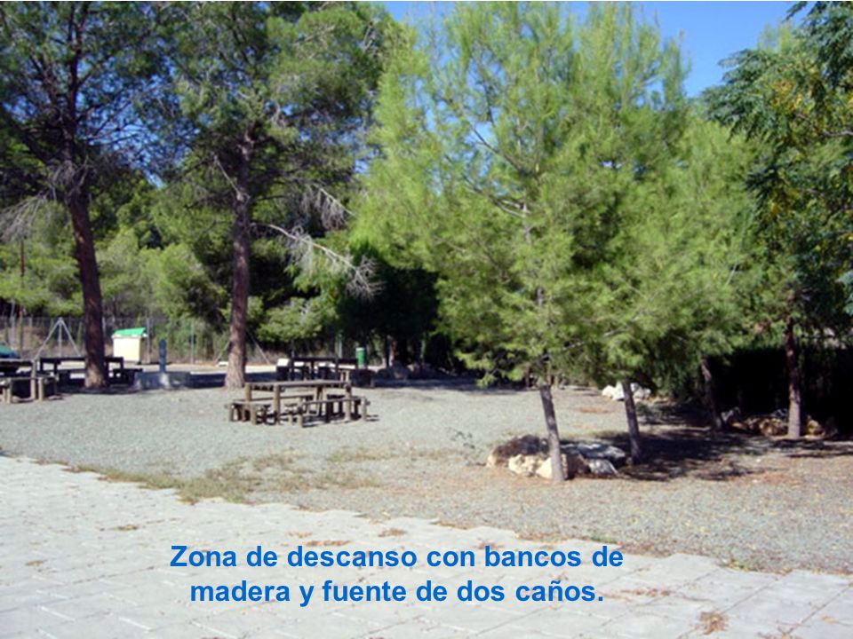 Zona de descanso con bancos de madera y fuente de dos caños.