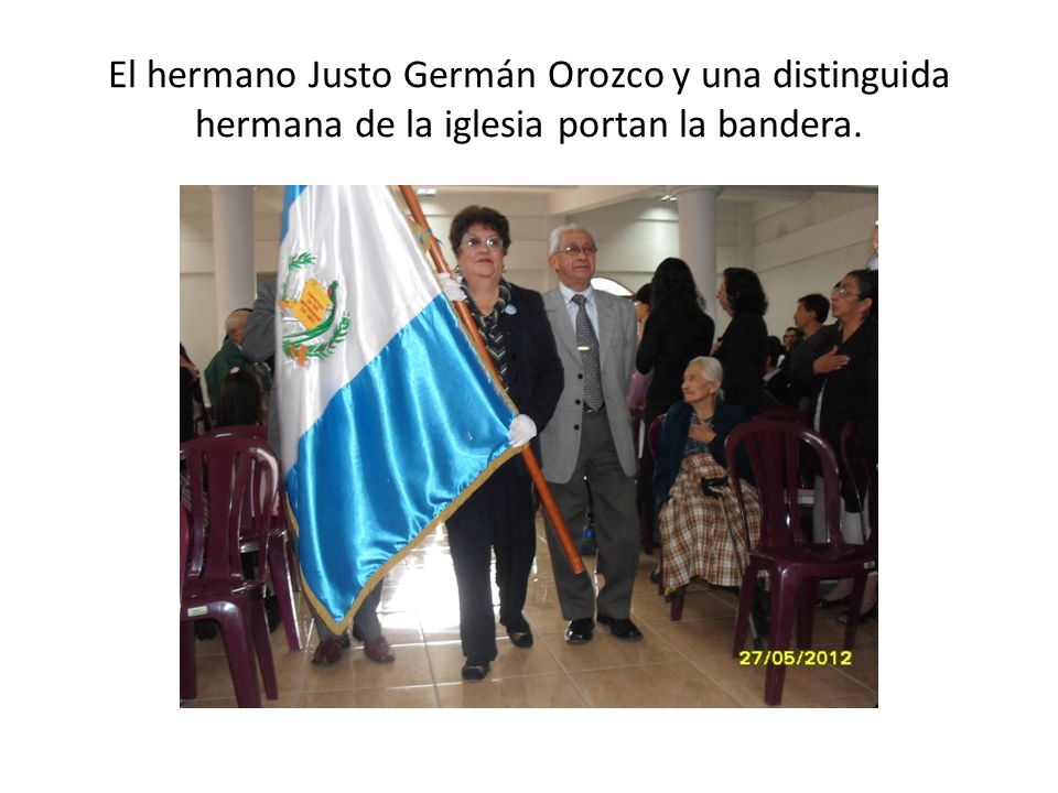 El hermano Justo Germán Orozco y una distinguida hermana de la iglesia portan la bandera.