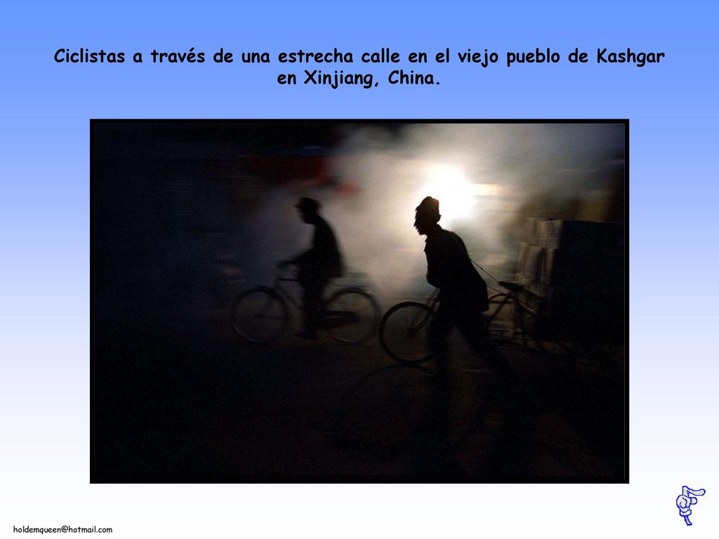Ciclistas a través de una estrecha calle en el viejo pueblo de Kashgar en Xinjiang, China.