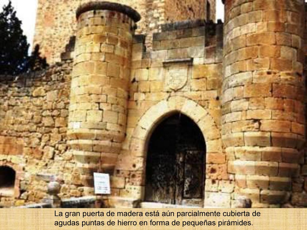 La gran puerta de madera está aún parcialmente cubierta de agudas puntas de hierro en forma de pequeñas pirámides.