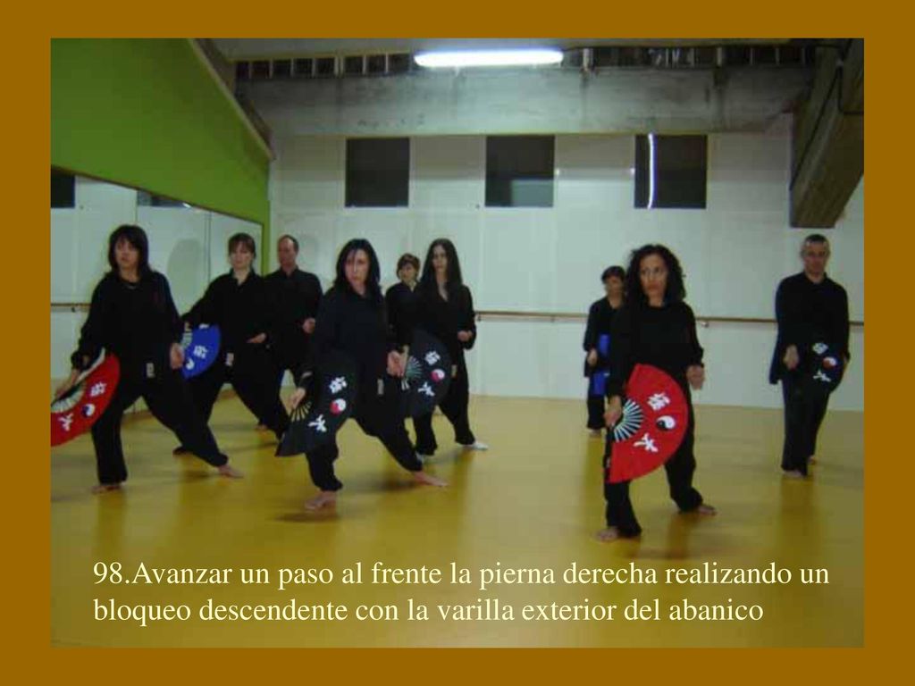 98.Avanzar un paso al frente la pierna derecha realizando un bloqueo descendente con la varilla exterior del abanico