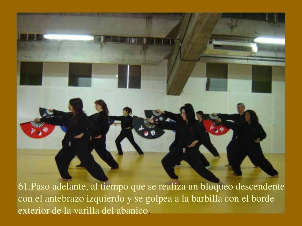 61.Paso adelante, al tiempo que se realiza un bloqueo descendente con el antebrazo izquierdo y se golpea a la barbilla con el borde exterior de la varilla del abanico.