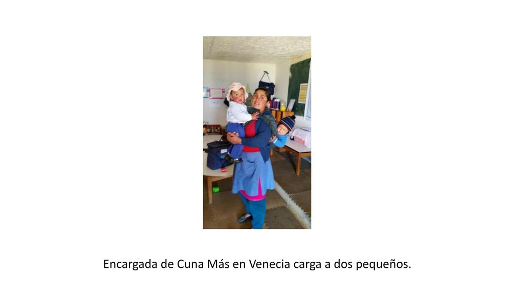 Encargada de Cuna Más en Venecia carga a dos pequeños.