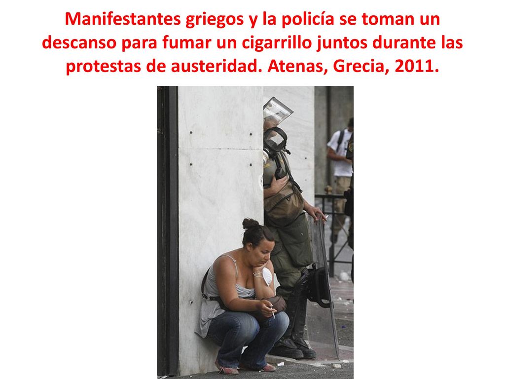 Manifestantes griegos y la policía se toman un descanso para fumar un cigarrillo juntos durante las protestas de austeridad.
