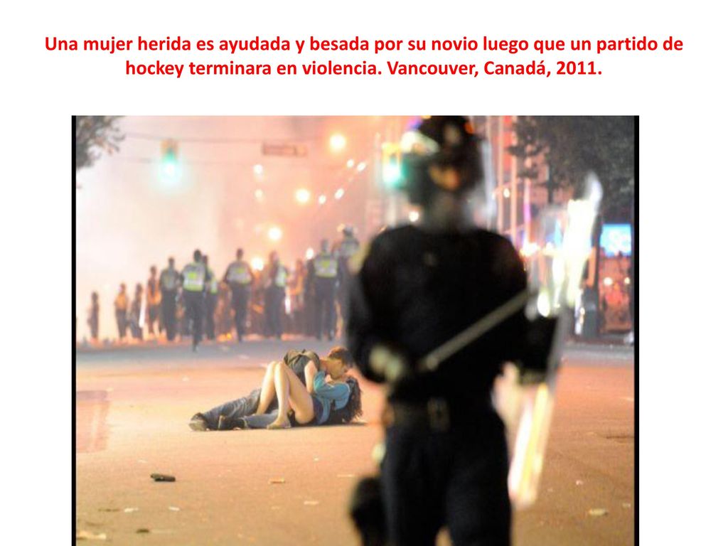 Una mujer herida es ayudada y besada por su novio luego que un partido de hockey terminara en violencia.