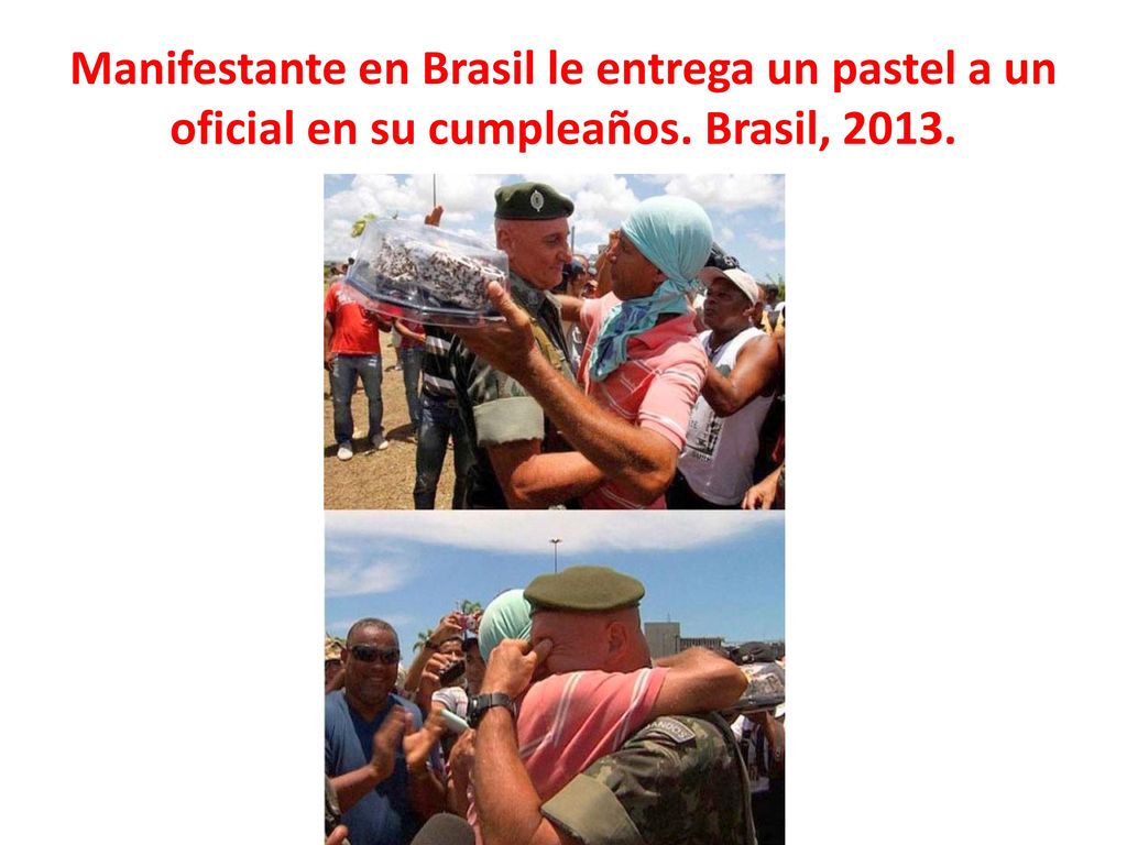 Manifestante en Brasil le entrega un pastel a un oficial en su cumpleaños. Brasil, 2013.