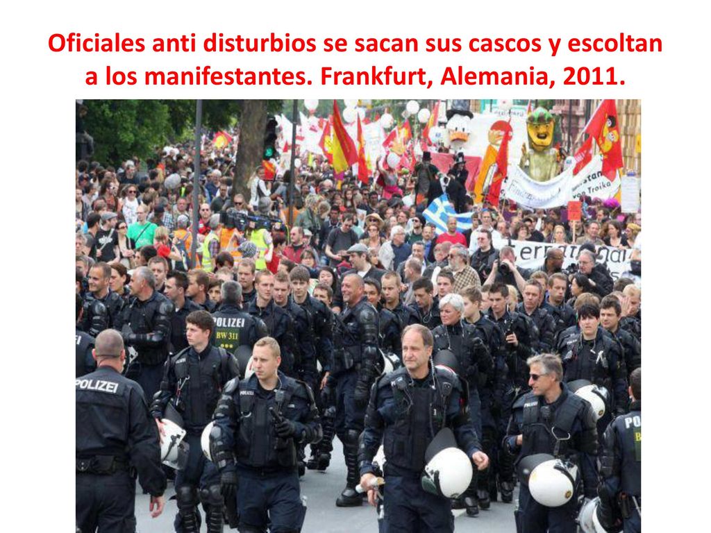 Oficiales anti disturbios se sacan sus cascos y escoltan a los manifestantes.