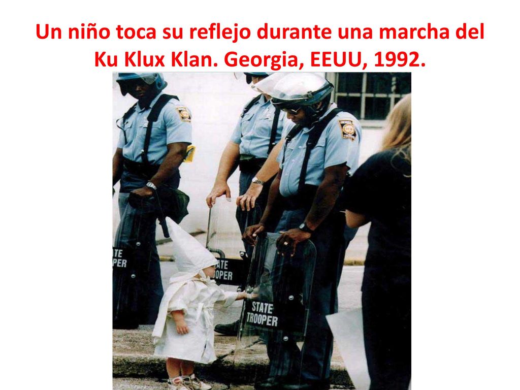 Un niño toca su reflejo durante una marcha del Ku Klux Klan