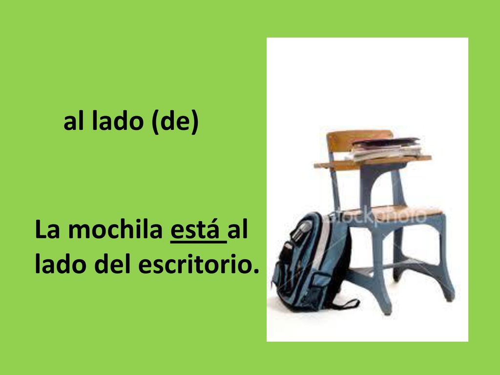al lado (de) La mochila está al lado del escritorio.