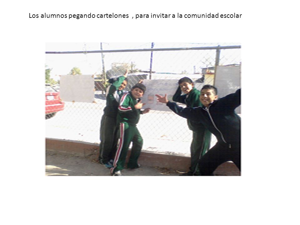 Los alumnos pegando cartelones , para invitar a la comunidad escolar