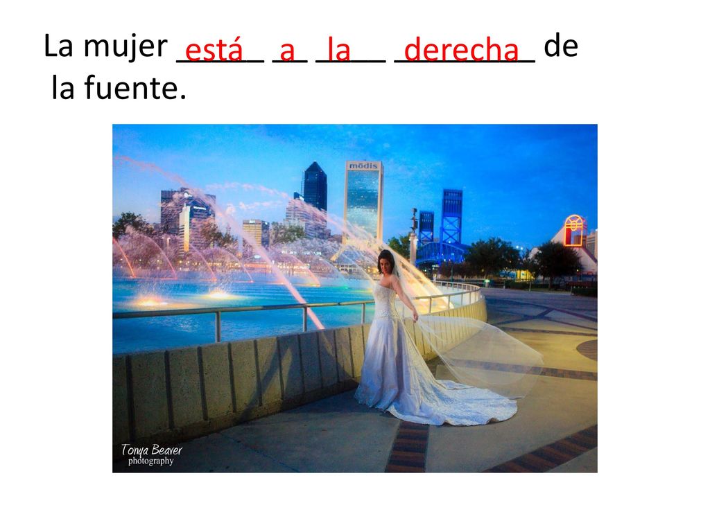 La mujer _____ __ ____ ________ de la fuente.