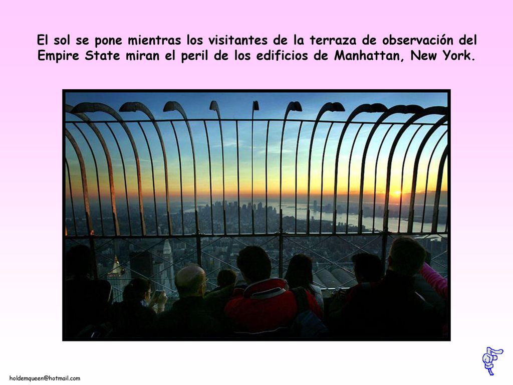El sol se pone mientras los visitantes de la terraza de observación del Empire State miran el peril de los edificios de Manhattan, New York.