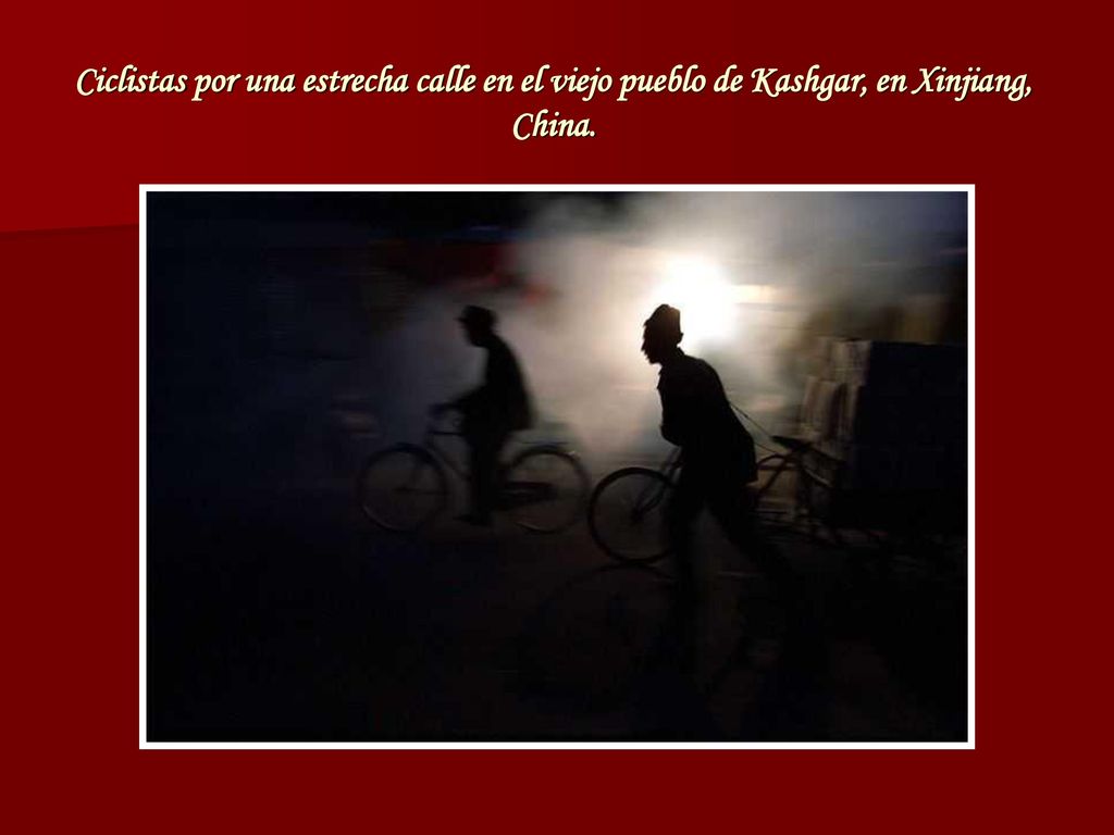 Ciclistas por una estrecha calle en el viejo pueblo de Kashgar, en Xinjiang, China.
