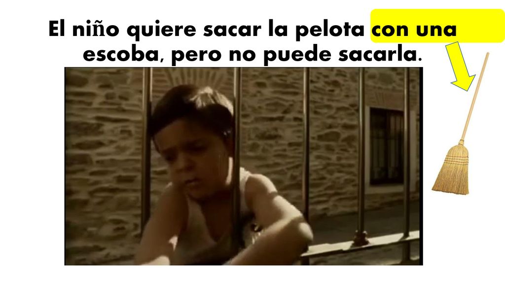 El niño quiere sacar la pelota con una escoba, pero no puede sacarla.