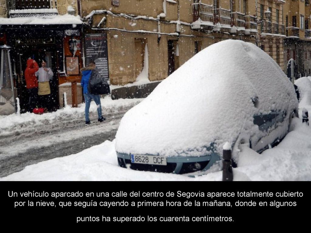 Un vehículo aparcado en una calle del centro de Segovia aparece totalmente cubierto por la nieve, que seguía cayendo a primera hora de la mañana, donde en algunos puntos ha superado los cuarenta centímetros.