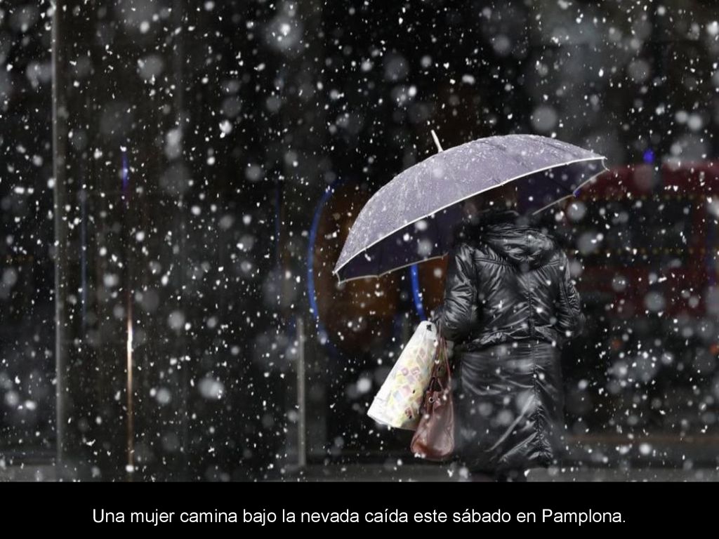 Una mujer camina bajo la nevada caída este sábado en Pamplona.