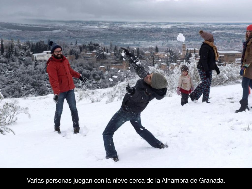Varias personas juegan con la nieve cerca de la Alhambra de Granada.