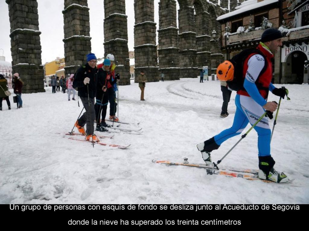 Un grupo de personas con esquís de fondo se desliza junto al Acueducto de Segovia donde la nieve ha superado los treinta centímetros