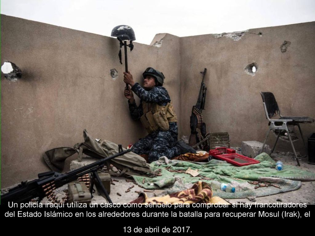 Un policía iraquí utiliza un casco como señuelo para comprobar si hay francotiradores del Estado Islámico en los alrededores durante la batalla para recuperar Mosul (Irak), el 13 de abril de 2017.
