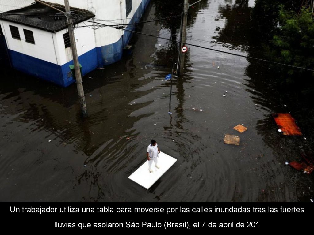 Un trabajador utiliza una tabla para moverse por las calles inundadas tras las fuertes lluvias que asolaron São Paulo (Brasil), el 7 de abril de 201