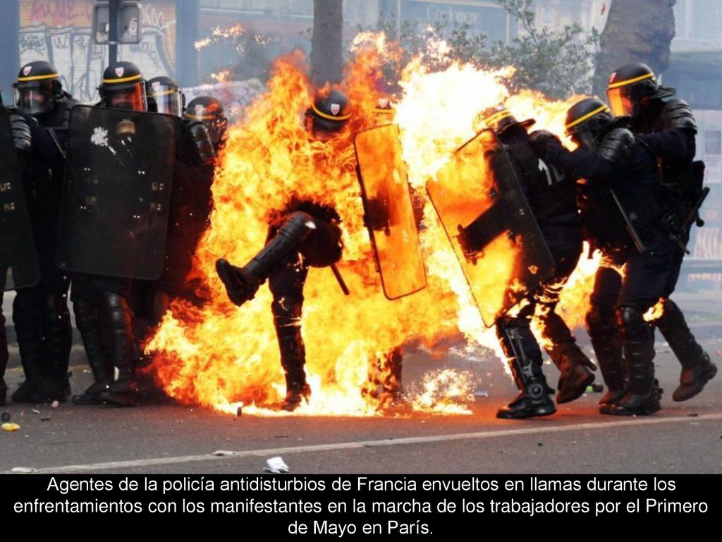 Agentes de la policía antidisturbios de Francia envueltos en llamas durante los enfrentamientos con los manifestantes en la marcha de los trabajadores por el Primero de Mayo en París.