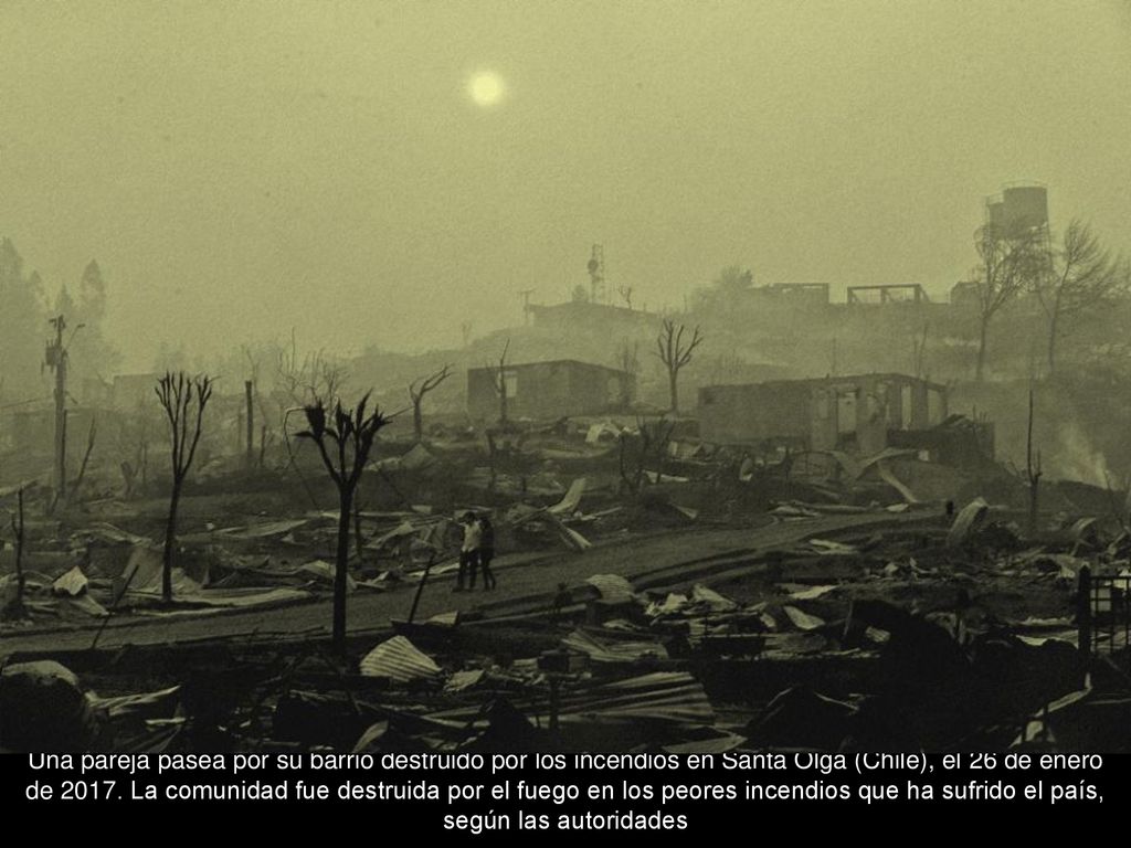 Una pareja pasea por su barrio destruido por los incendios en Santa Olga (Chile), el 26 de enero de 2017.