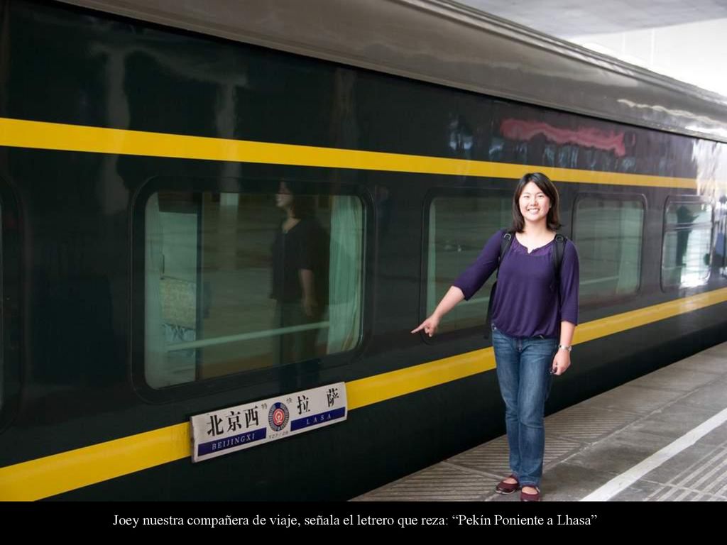 Joey nuestra compañera de viaje, señala el letrero que reza: Pekín Poniente a Lhasa