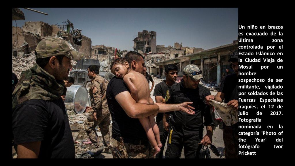 Un niño en brazos es evacuado de la última zona controlada por el Estado Islámico en la Ciudad Vieja de Mosul por un hombre sospechoso de ser militante, vigilado por soldados de las Fuerzas Especiales iraquíes, el 12 de julio de 2017.
