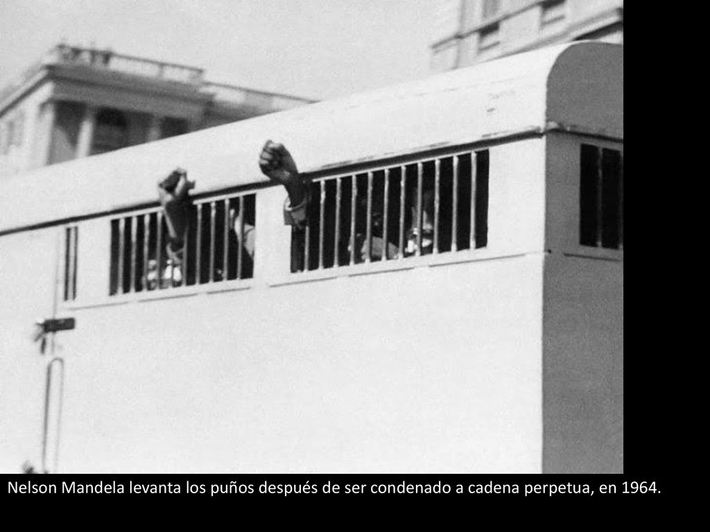 Nelson Mandela levanta los puños después de ser condenado a cadena perpetua, en 1964.