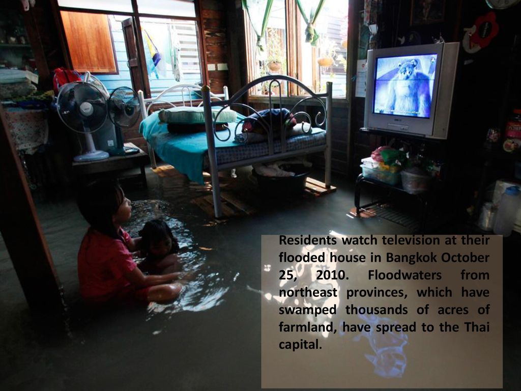 Residents watch television at their flooded house in Bangkok October 25, 2010.