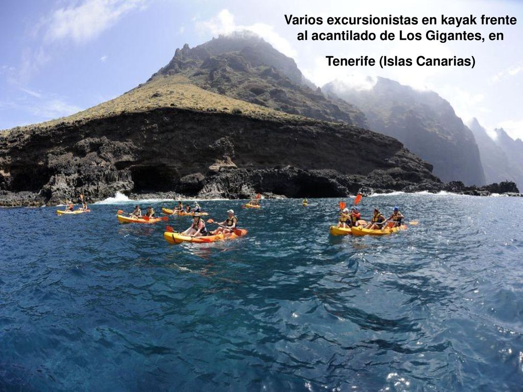 Varios excursionistas en kayak frente al acantilado de Los Gigantes, en Tenerife (Islas Canarias)