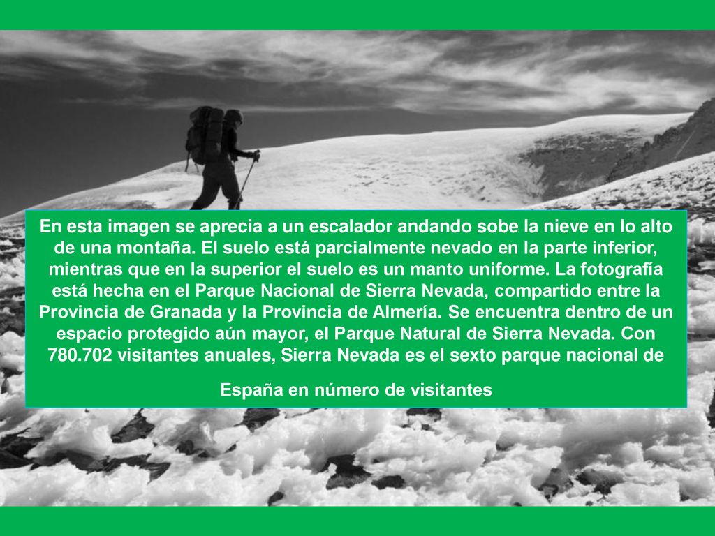 En esta imagen se aprecia a un escalador andando sobe la nieve en lo alto de una montaña.