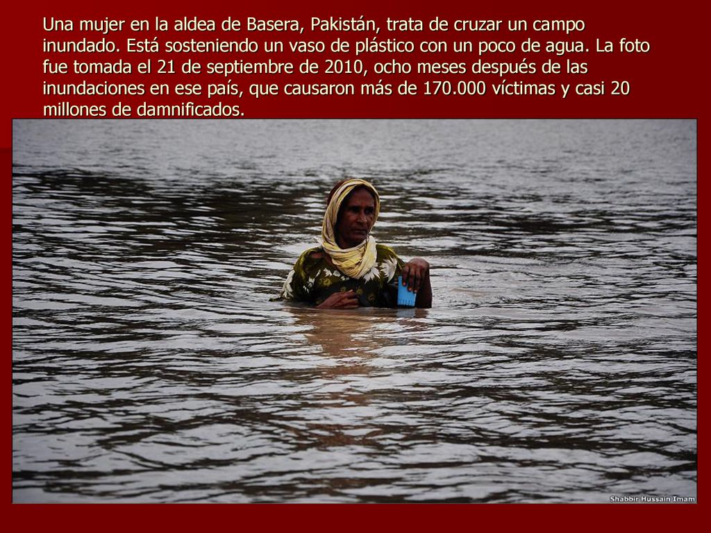 Una mujer en la aldea de Basera, Pakistán, trata de cruzar un campo inundado.