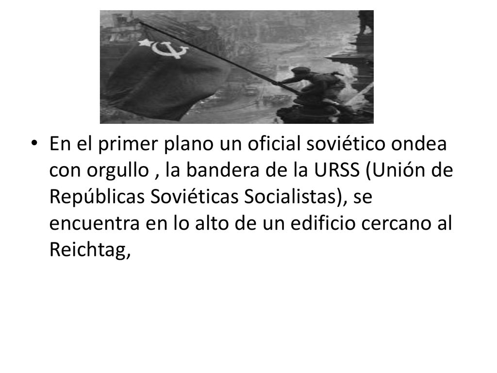 En el primer plano un oficial soviético ondea con orgullo , la bandera de la URSS (Unión de Repúblicas Soviéticas Socialistas), se encuentra en lo alto de un edificio cercano al Reichtag,