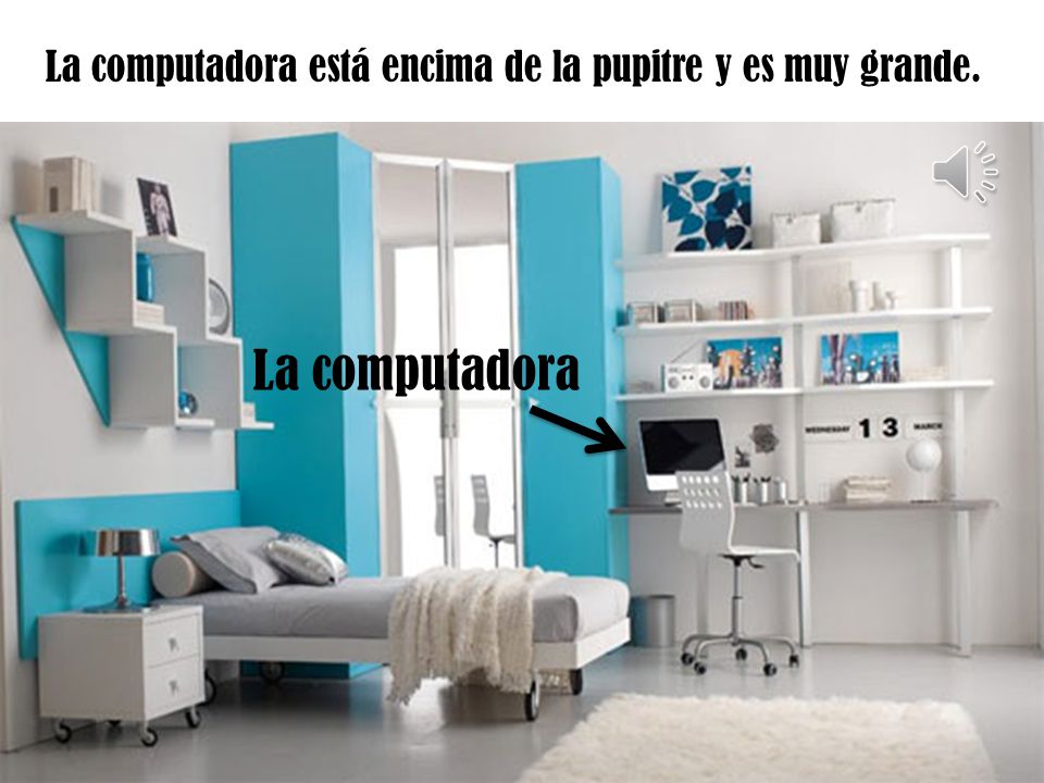 La computadora está encima de la pupitre y es muy grande.