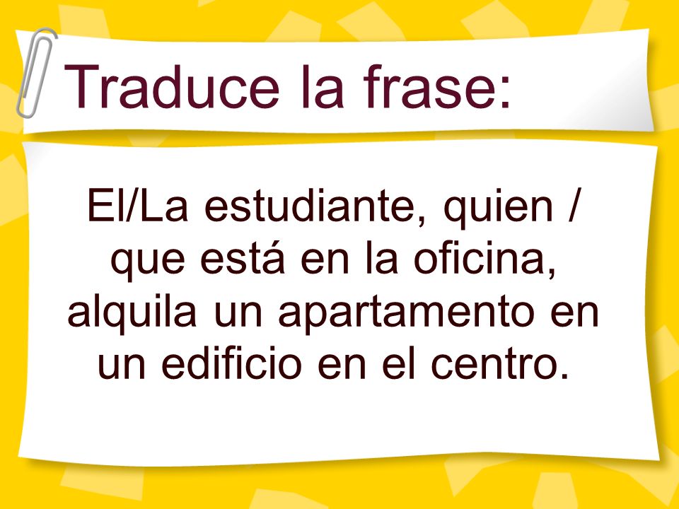 Traduce la frase: El/La estudiante, quien / que está en la oficina, alquila un apartamento en un edificio en el centro.