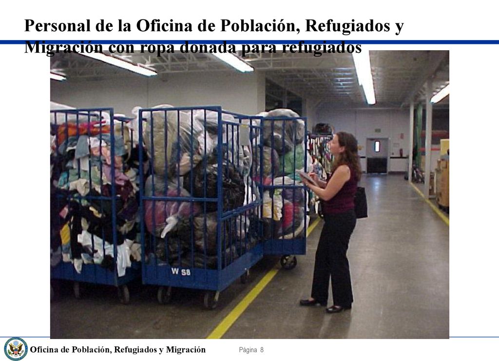 Personal de la Oficina de Población, Refugiados y Migración con ropa donada para refugiados
