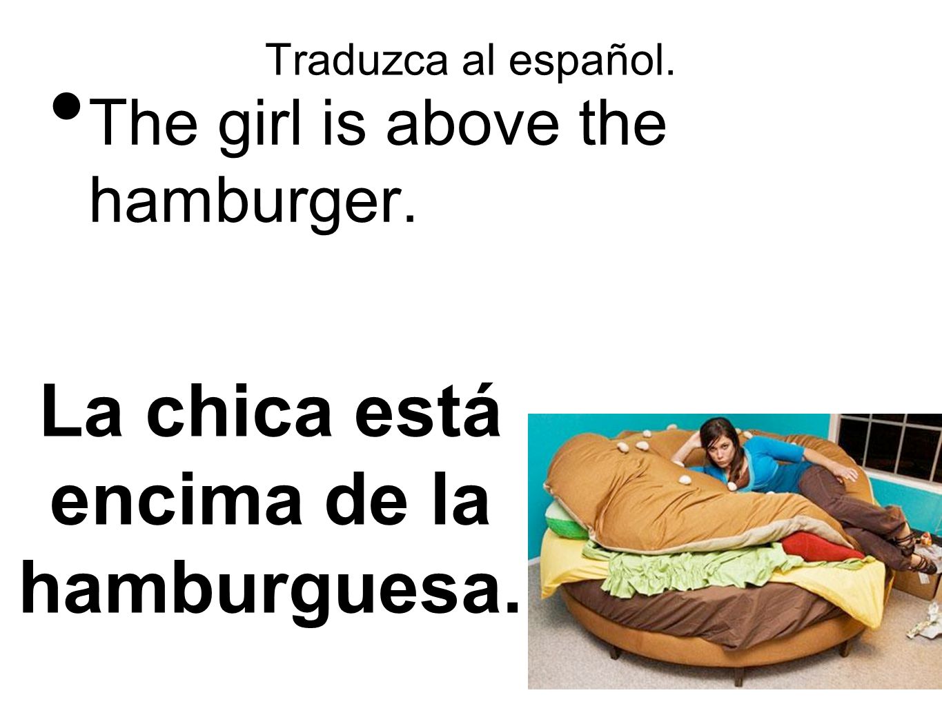 La chica está encima de la hamburguesa.