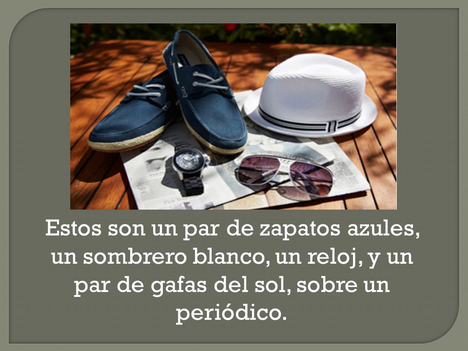 Estos son un par de zapatos azules, un sombrero blanco, un reloj, y un par de gafas del sol, sobre un periódico.