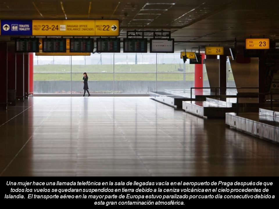 Una mujer hace una llamada telefónica en la sala de llegadas vacía en el aeropuerto de Praga después de que todos los vuelos se quedaran suspendidos en tierra debido a la ceniza volcánica en el cielo procedentes de Islandia.