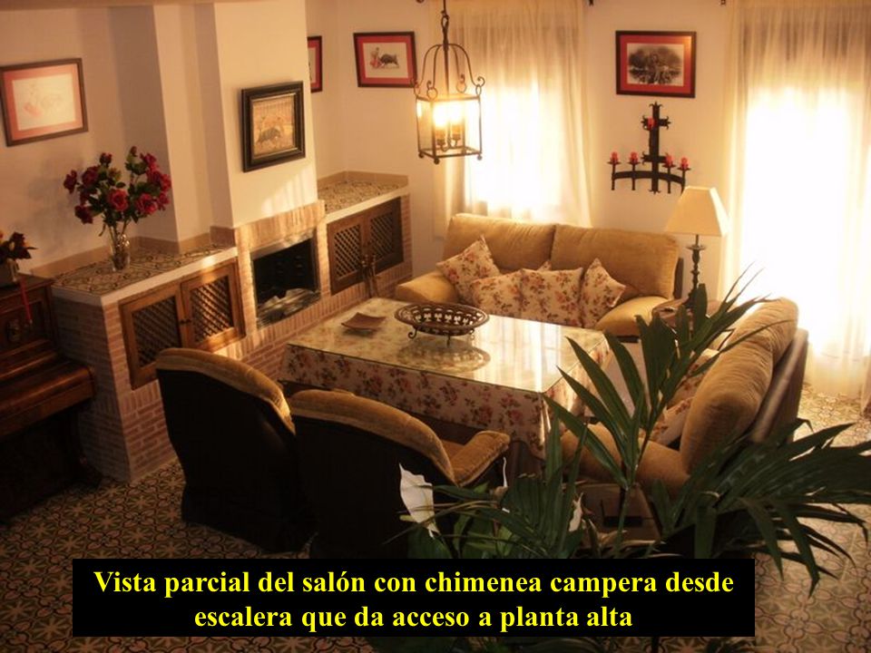 Vista parcial del salón con chimenea campera desde escalera que da acceso a planta alta