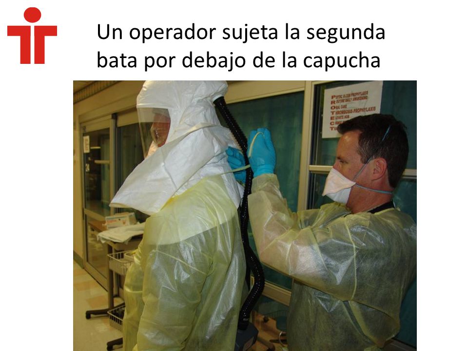 Un operador sujeta la segunda bata por debajo de la capucha