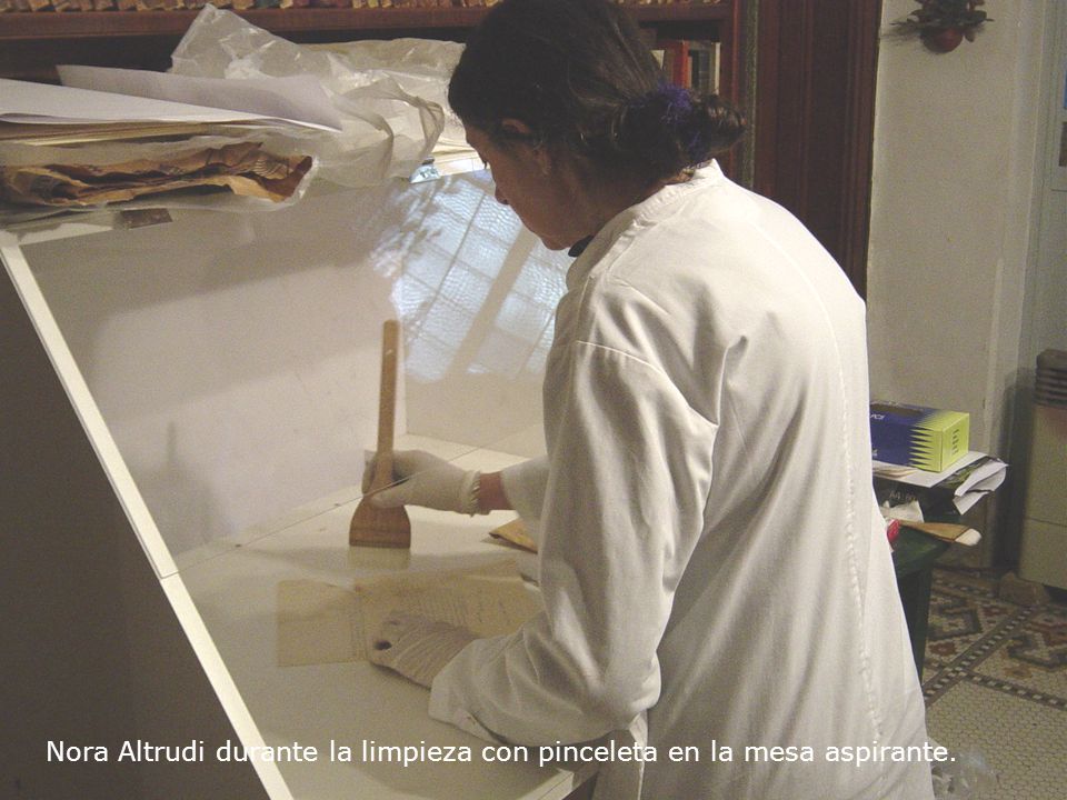 Nora Altrudi durante la limpieza con pinceleta en la mesa aspirante.