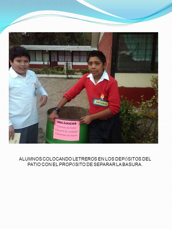 ALUMNOS COLOCANDO LETREROS EN LOS DEPÓSITOS DEL PATIO CON EL PROPÓSITO DE SEPARAR LA BASURA.