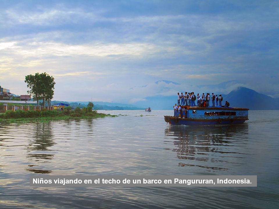 Niños viajando en el techo de un barco en Pangururan, Indonesia.