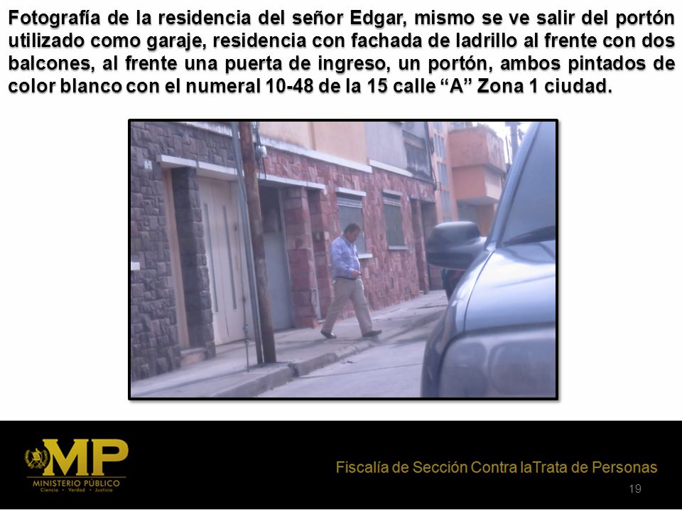 Fotografía de la residencia del señor Edgar, mismo se ve salir del portón utilizado como garaje, residencia con fachada de ladrillo al frente con dos balcones, al frente una puerta de ingreso, un portón, ambos pintados de color blanco con el numeral de la 15 calle A Zona 1 ciudad.